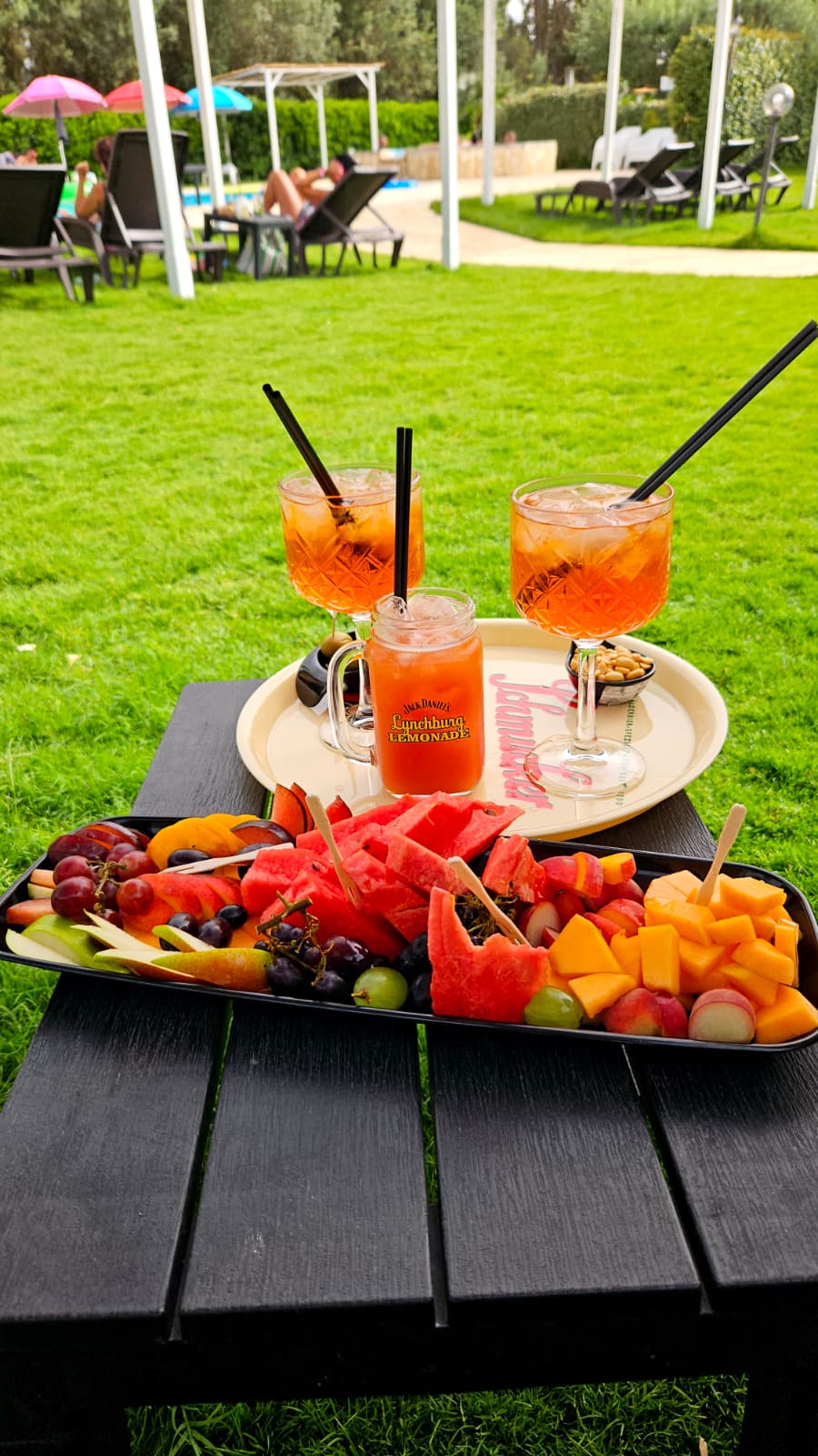 Cocktail e tagliere di frutta fresca in giardino